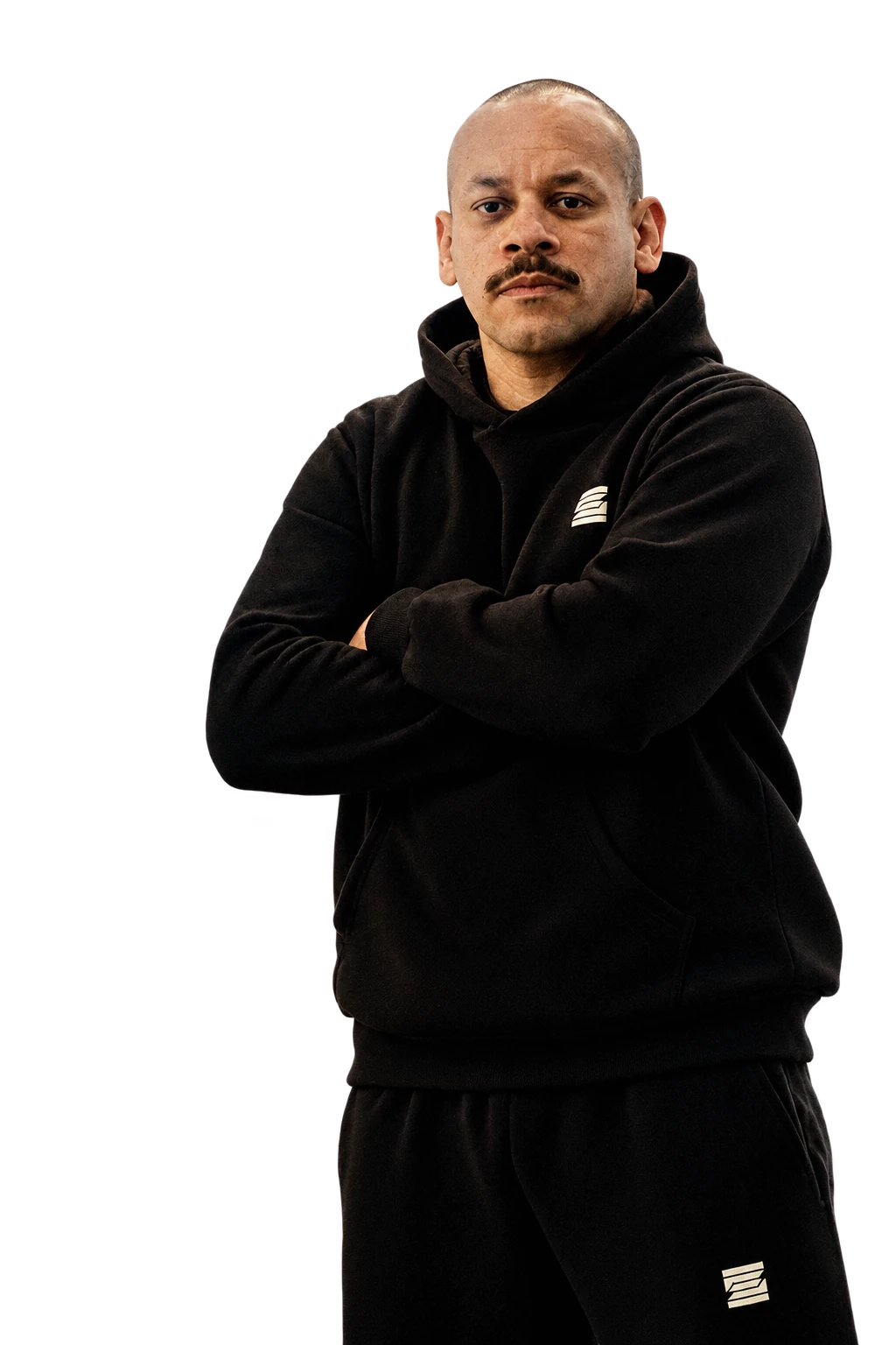 Homem de bigode da F. Silva Combat School, de braços cruzados.